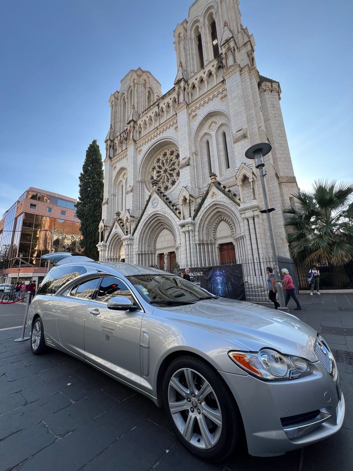Le corbillard des Pompes Funèbres des Oliviers devant une église